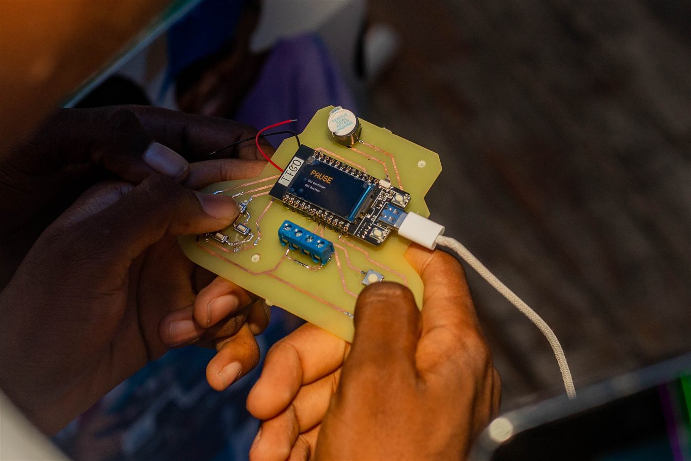 Un Arduboy assemblé, tenu en main, écran allumé
