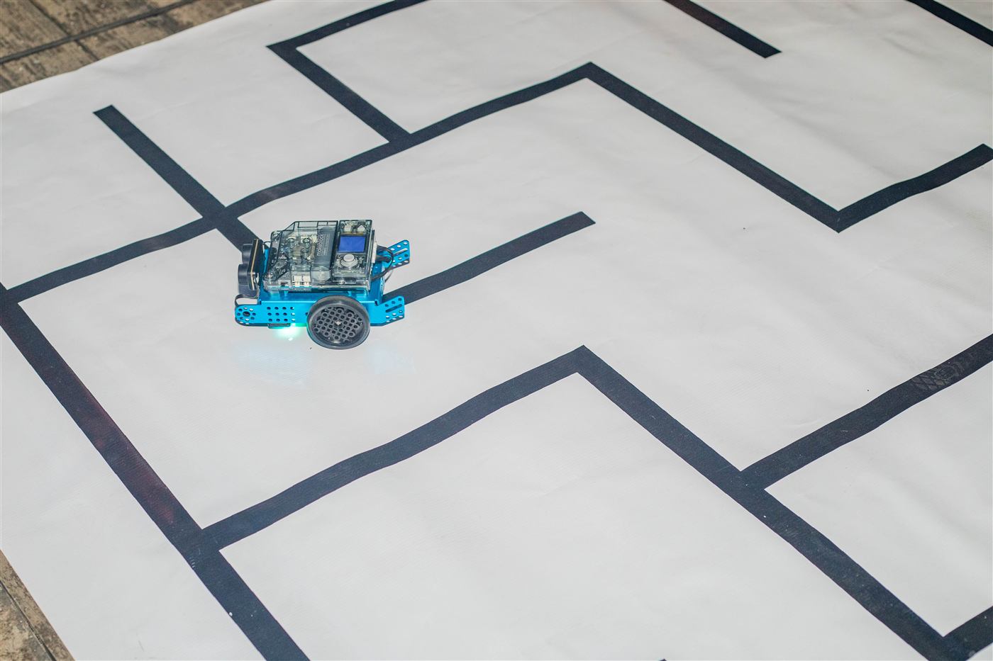 Un robot mBot dans un labyrinthe tracé au sol