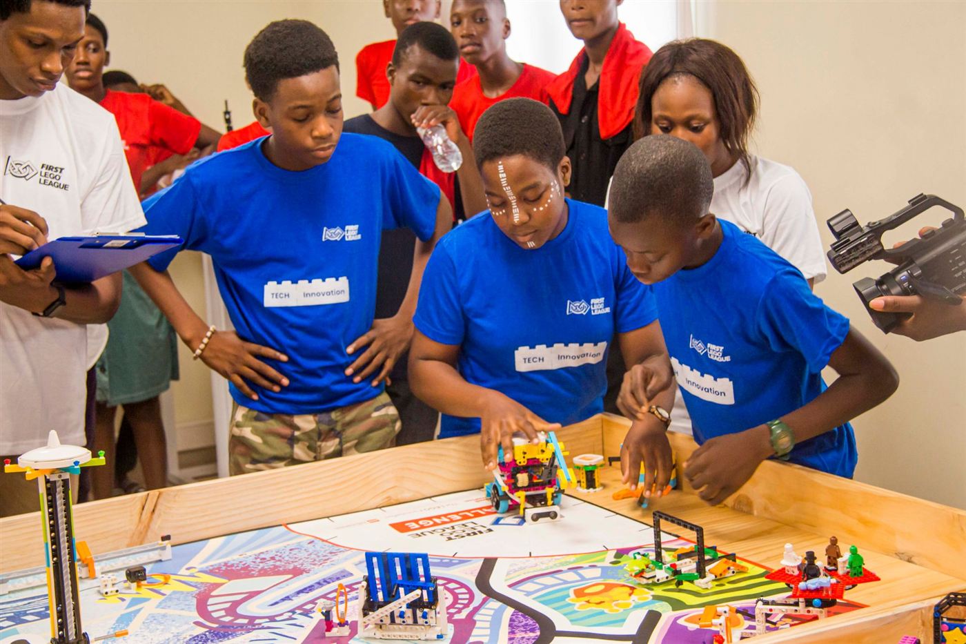 L'équipe TECH Innovation en t-shirts bleus prépare son robot sur la table