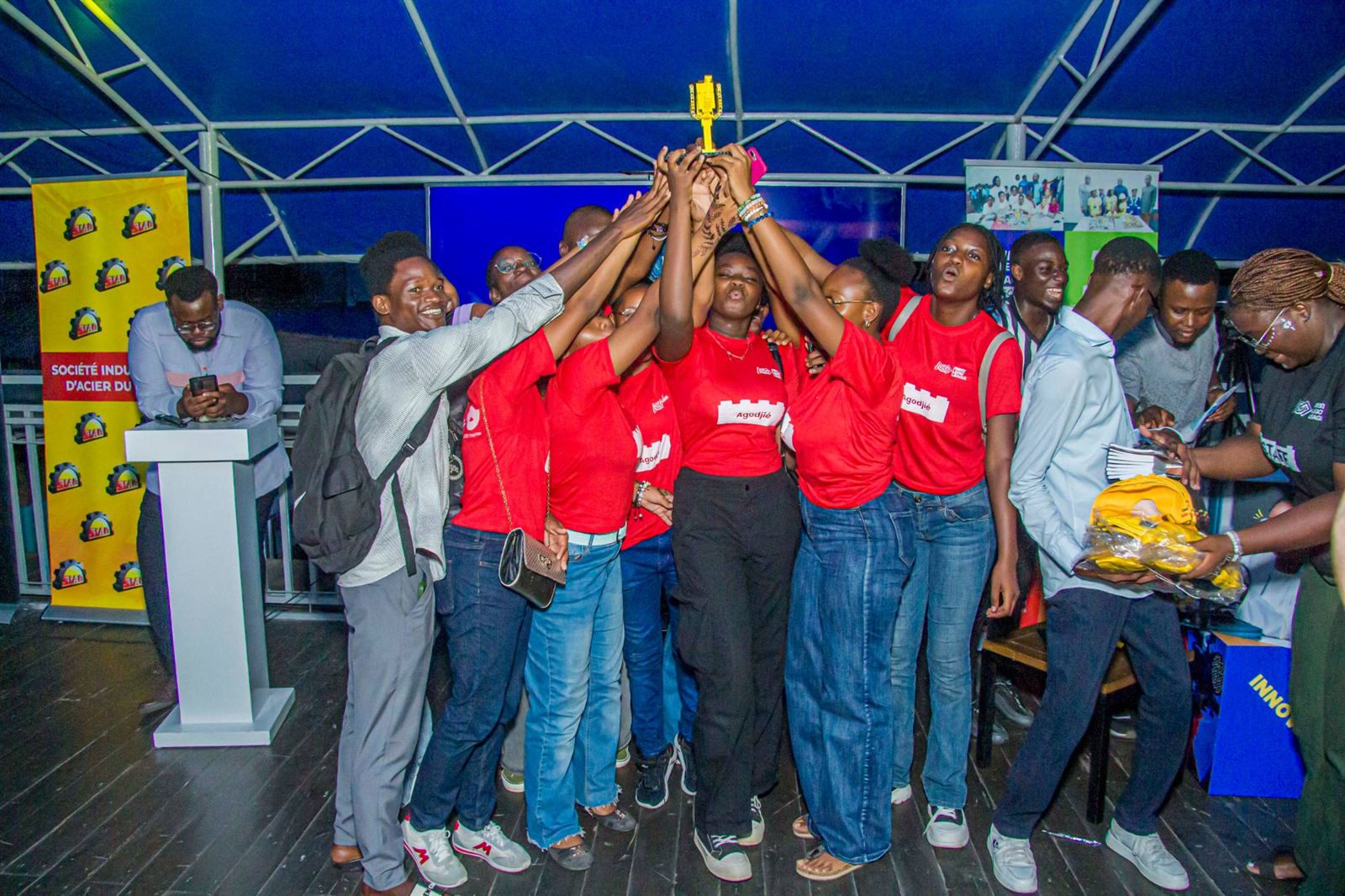 L'équipe Agodjié en t-shirts rouges lève son trophée