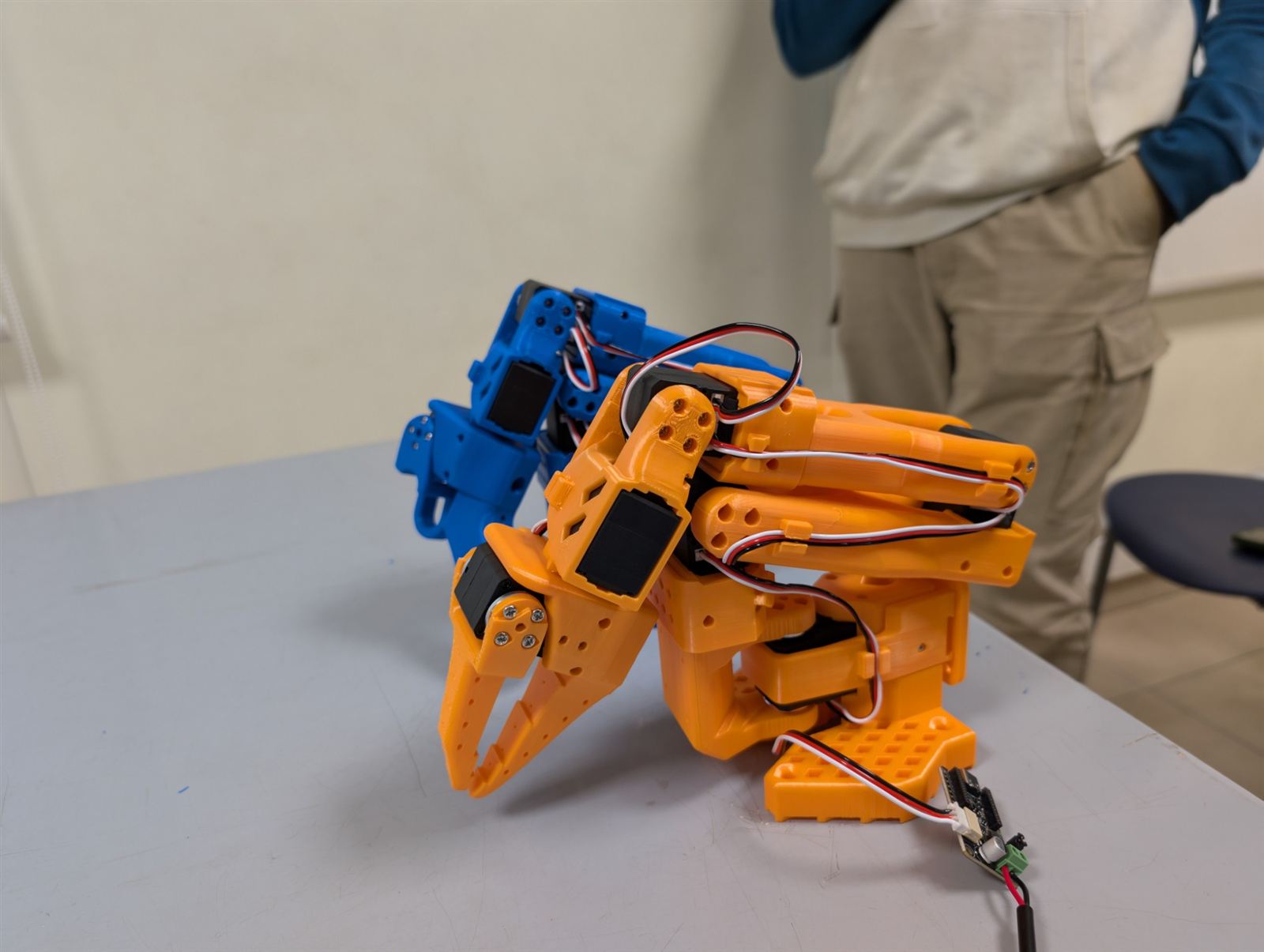 Deux bras assemblés, bleu et orange, en position repliée