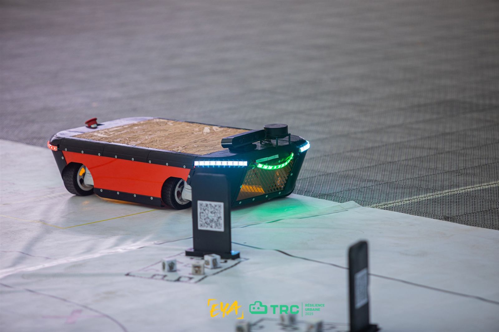 Le robot Silvy, flancs rouges et bandeaux LED verts, sur l'arène du TEKBOT Robotics Challenge 2025