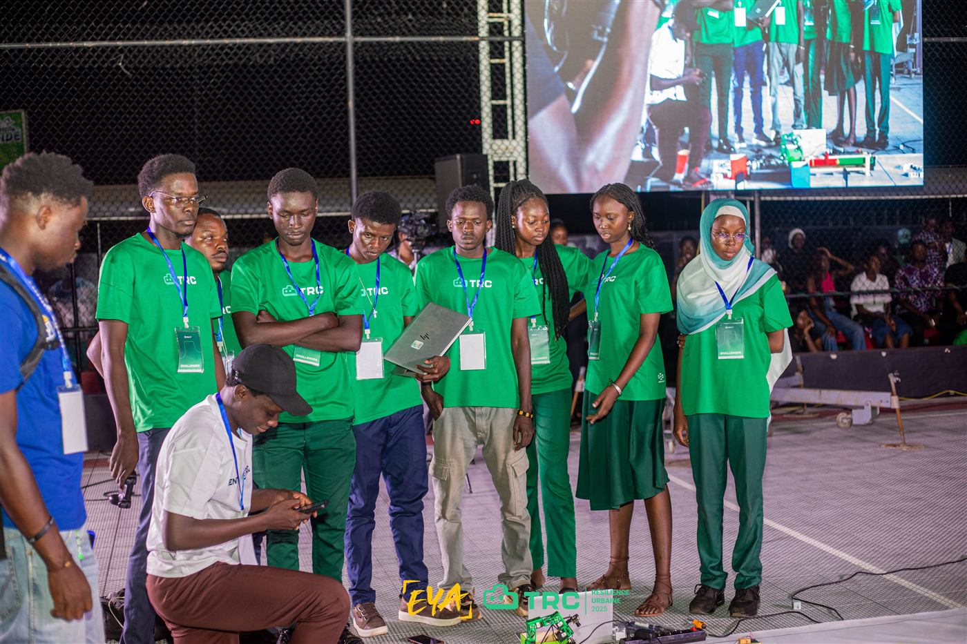Une équipe finaliste en t-shirts verts aligne son robot avant un match